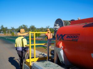 "We'd Recommend This to Anyone" - Ground Tamers on Their VX2000 Hydromulcher 5 Contractors with a hydroseeder and spraying hydroseed in the background for the 'How much does a hydroseeder Cost?' Article.